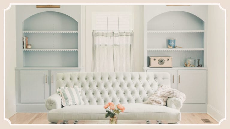 Sitting room at The Cottage at Foxhavens featuring original built-in bookcases, a tufted sofa, and soft morning light.