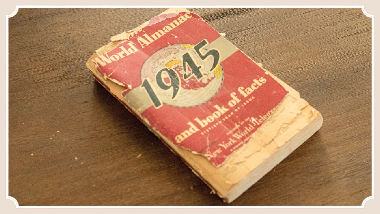 A vintage 1945 almanac resting on a handmade wooden table at The Cottage at Foxhavens.