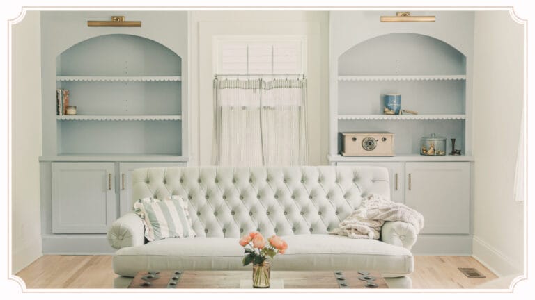 Sitting room at The Cottage at Foxhavens featuring original built-in bookcases, a tufted sofa, and soft morning light.