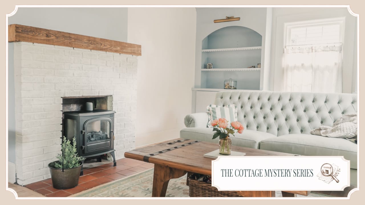 White brick fireplace with a wood mantel and black stove in the sitting room of The Cottage at Foxhavens.